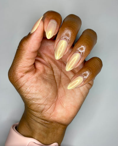Hand with fingernails painted with a gold shimmer shade