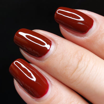 Picture of fingernails painted with a deep maroon vegan non- toxic nail polish