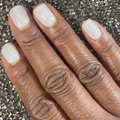 Picture of fingernails painted with a milky white non toxic vegan nail polish